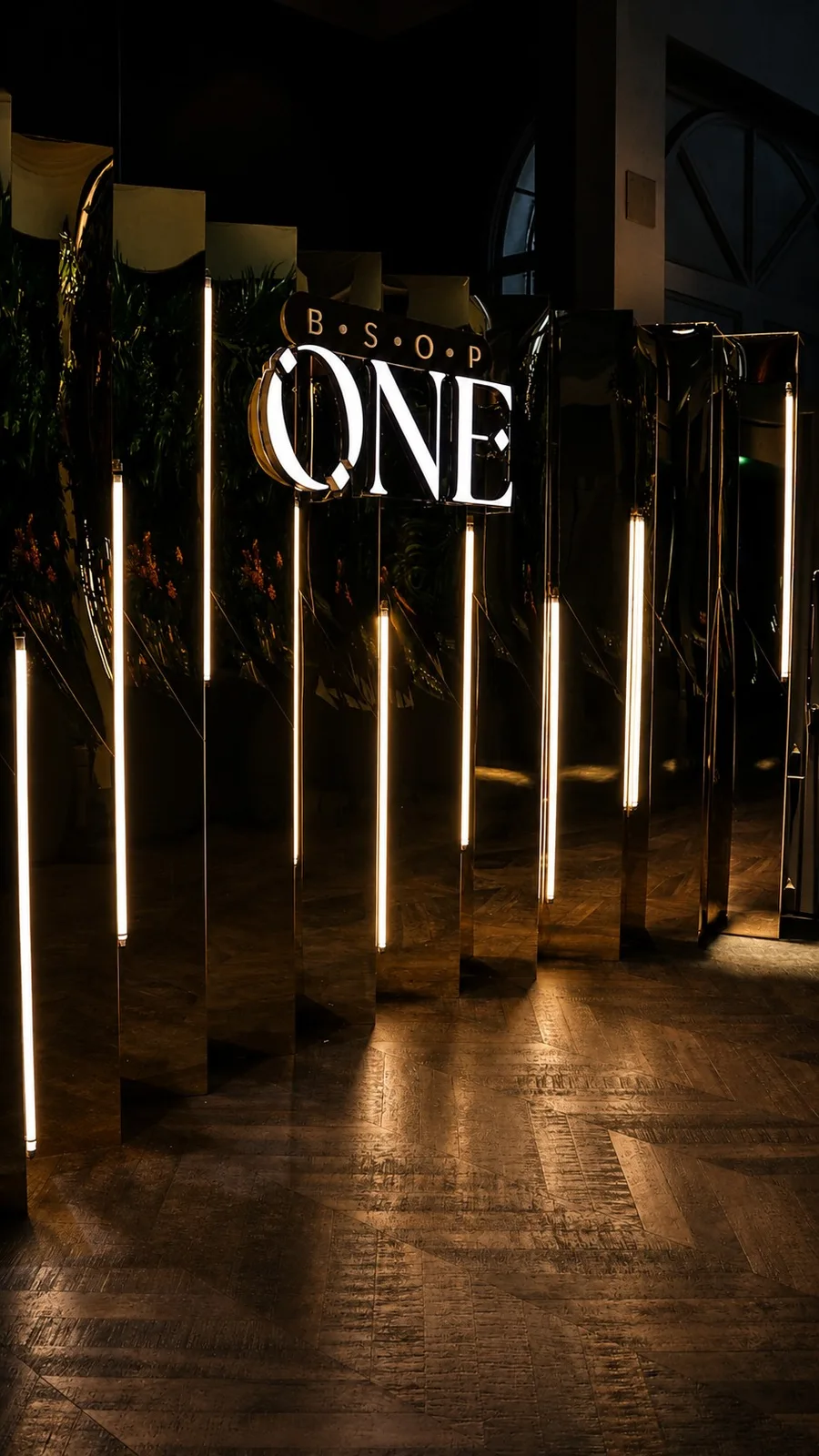 Instalação ONE com elementos espelhados e iluminação vertical no projeto BSOP